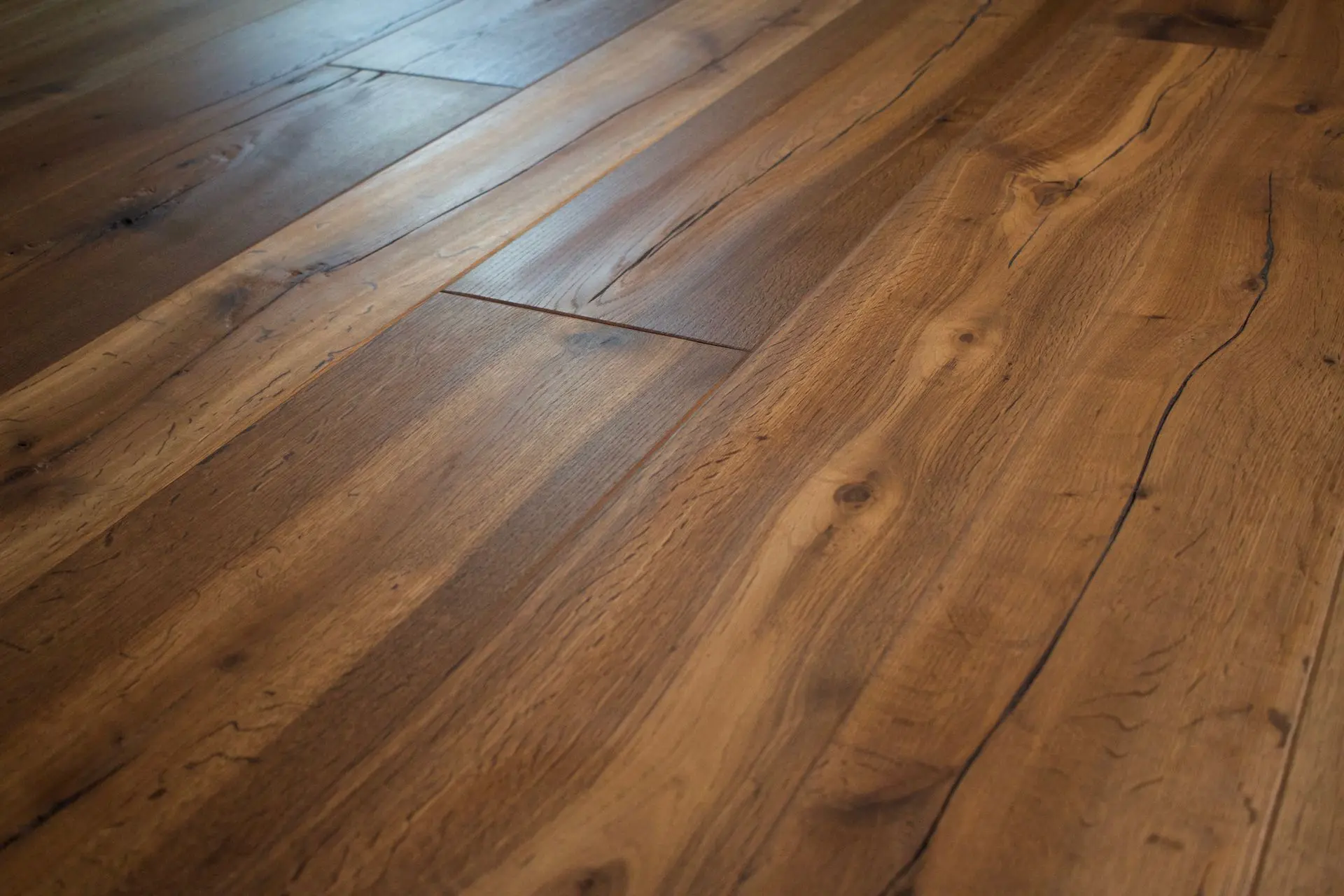 Detailní pohled na bohatou texturu a hluboké tóny dubové podlahy Naturale ošetřené přírodním olejem pro zvýraznění kresby dřeva.