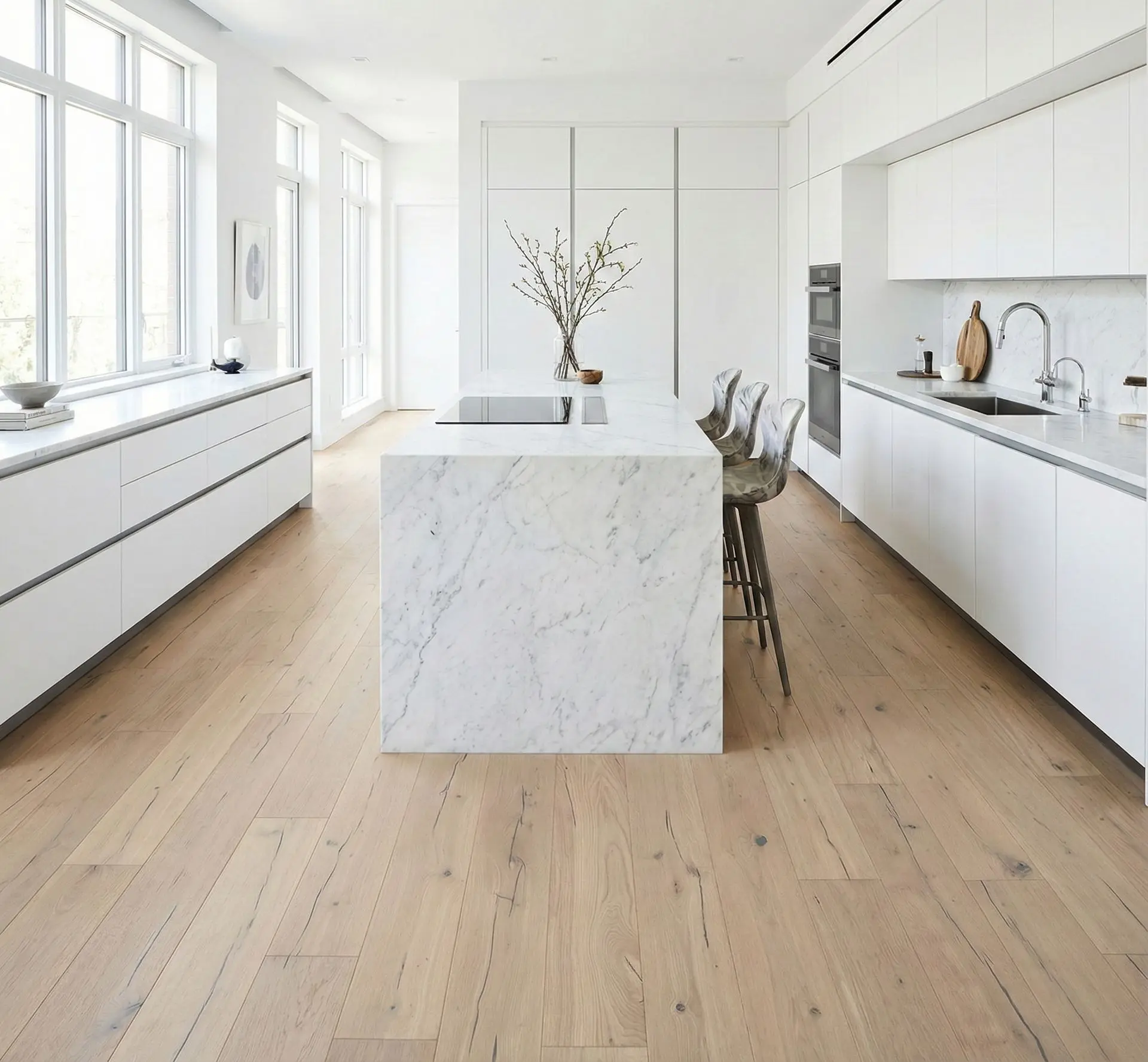 Moderní bílá kuchyně s mramorovým ostrůvkem a světlou dubovou podlahou Pure, která vnáší přírodní teplo do minimalistického interiéru.